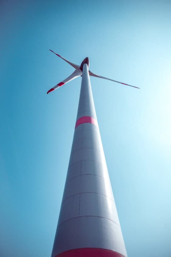 Turm einer Windenergieanlage von unten fotografiert vor blauem Himmel