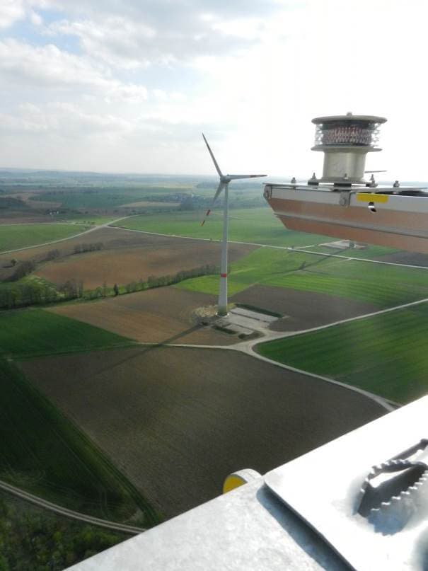 Blick aus der Gondel einer Windenergieanlage auf Felder und eine weitere Anlage
