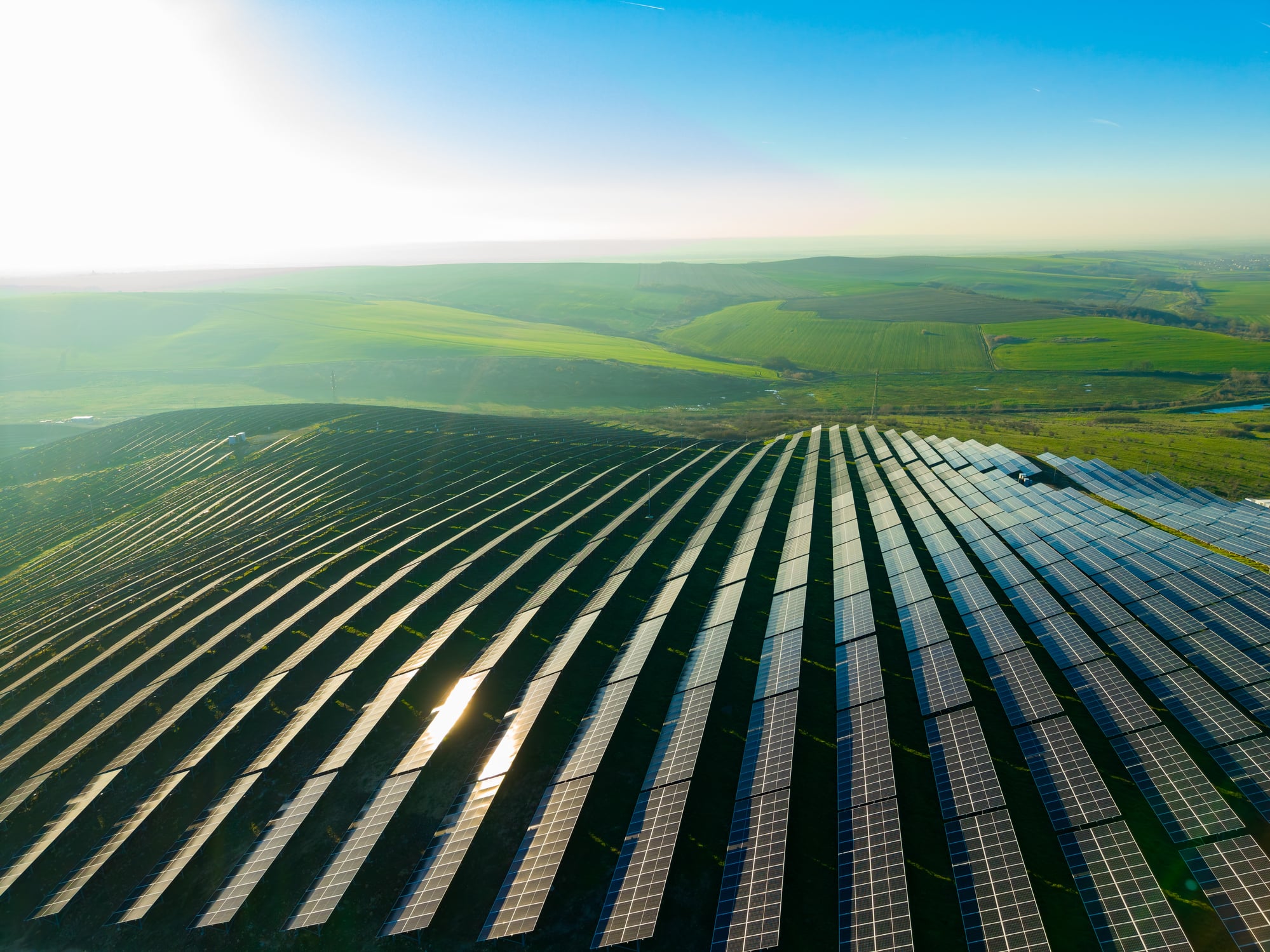 Freiflächen-Photovoltaikanlage auf einer Anhöhe im Gegenlicht